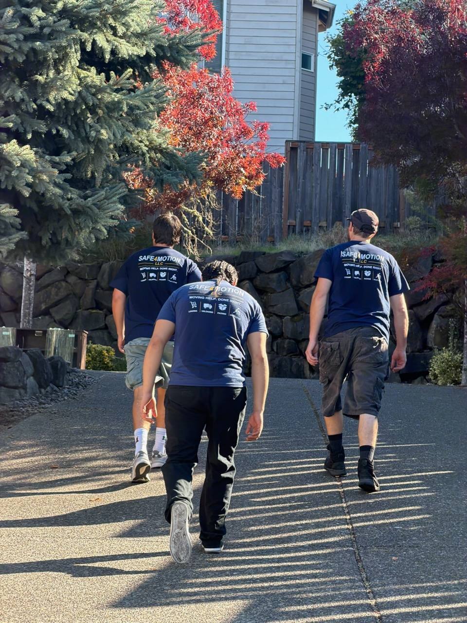 Three Safe4Motion movers walking together in matching navy company shirts